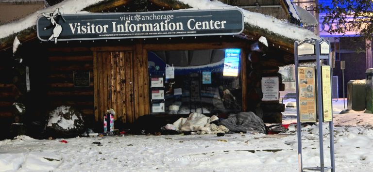 Street people camp in doorway of Anchorage Visitor Center as winter sets in